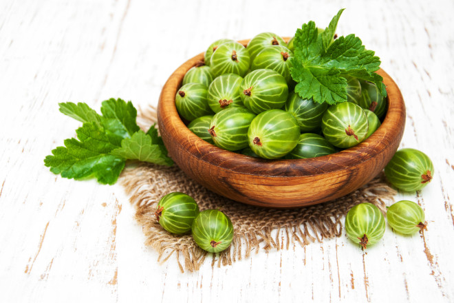 gooseberries with leaves on a old wooden background