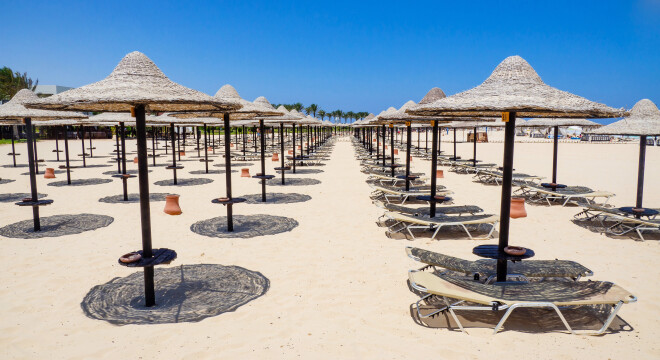 Marsa Matruh, Egypt. August 1, 2019. Rows of umbrellas made of straw and sunbeds. Sandy beach. Relaxing context. Fabulous holidays. Mediterranean Sea. North Africa