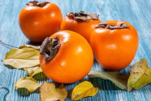 Persimmon fruit on rustic table in vintage style