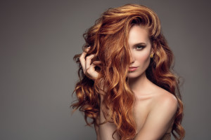 Portrait of woman with long curly beautiful ginger hair.