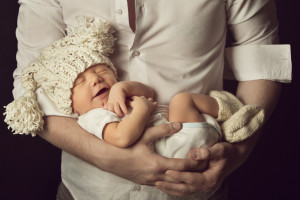 newborn baby boy smiling in woolen hat sleeping on father hand small kid happy laughing