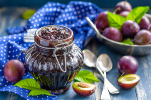 Plum jam and fresh fruits with leaves