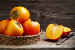 fresh ripe persimmons on wooden table