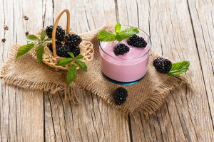 Bramble smoothie with berries on a rustic wooden table