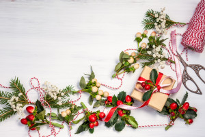 Christmas presents and winter natural garlands on the white wooden background