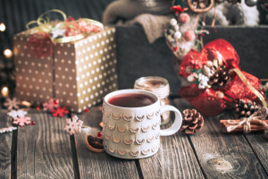 Homemade mulled wine on a wooden background with Christmas decor and a sweater, the concept of hot seasonal drinks