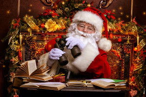 Santa Claus is preparing for Christmas, he looks through binoculars. House of Santa Claus. Christmas decoration.