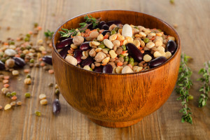 Multicolored mixed beans and lentils on a rustic wooden table