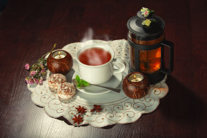 Cup of tea and teapot on dark background