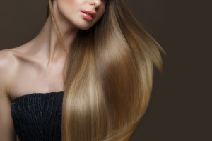 Beautiful blond girl with a perfectly smooth hair, classic make-up. Beauty face. Picture taken in the studio on a white background.