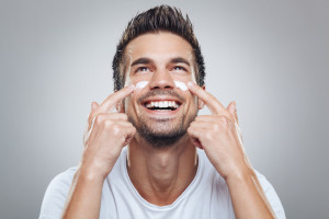 Young man with moisturizer on the face