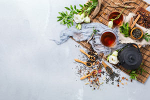 Food and drink still life concept. Selection assortment of different japanese chinese herbal masala tea infusion beverage teapot with white flowers on the table. Top view copy space background