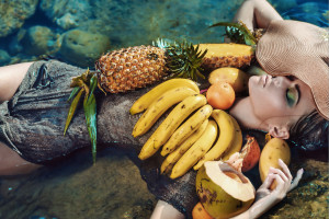 Fashionable woman posing with tropical fruits