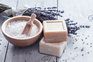 Natural soap, lavender, salt on a wooden board, hygiene items for bath and spa.