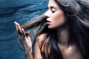 sensual woman portrait, long hair in motion, profile, studio shot
