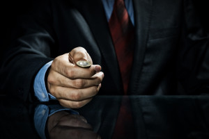 Close up of businessman holding coin in hand