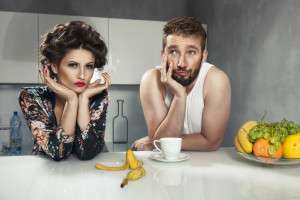 Funny couple after breakfast. Strange faces. Young man and beauty woman in kitchen