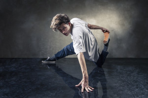 urban hip hop dancer with grunge concrete wall background texture jumping and dancing
