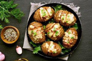 Delicious baked potatoes with bacon, green onion and cheese. Dish for dinner. Close up view. Top view, flat lay