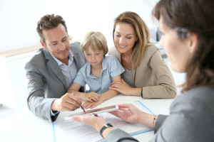 Family signing home purchase contract on tablet