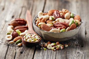 Mix nuts on a wooden background. Cut nuts