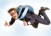 Portrait of happy man flying with parachute and showing thumbs up