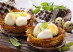 Boiled quail eggs in baked nests of potatoes. With sage and rosemary. On wooden table.