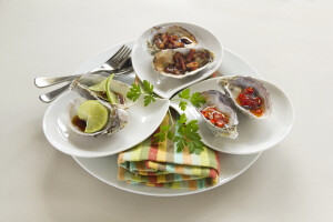 Platter of oysters including oysters kilpatrick with sweet chilli and with lime and soy sauce.