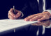 Retro image of lawyer signing important legal document on black desk. Over black background.